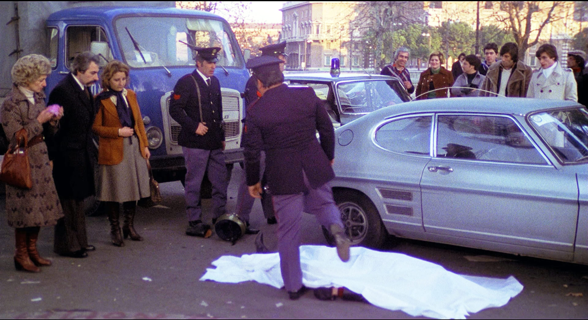 1976 _ Uomini Si Nasce Poliziotti Si Muore _ Donna In Strada Che Guarda Il Cadavere Del Ladro Motociclista _ Non Accreditato _ 01.jpg