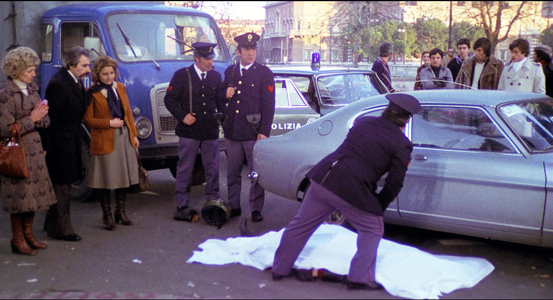 1976 _ Uomini Si Nasce Poliziotti Si Muore _ Donna In Strada Che Guarda Il Cadavere Del Ladro Motociclista _ Non Accreditato _ 02.jpg